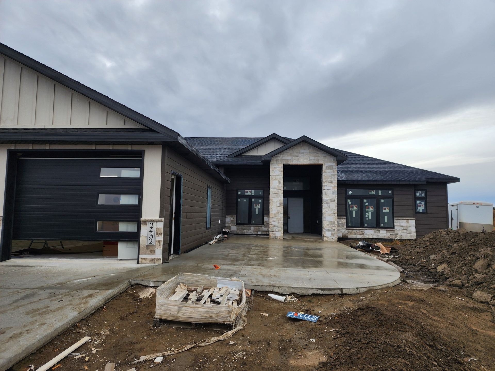 a large house with a black garage door is under construction