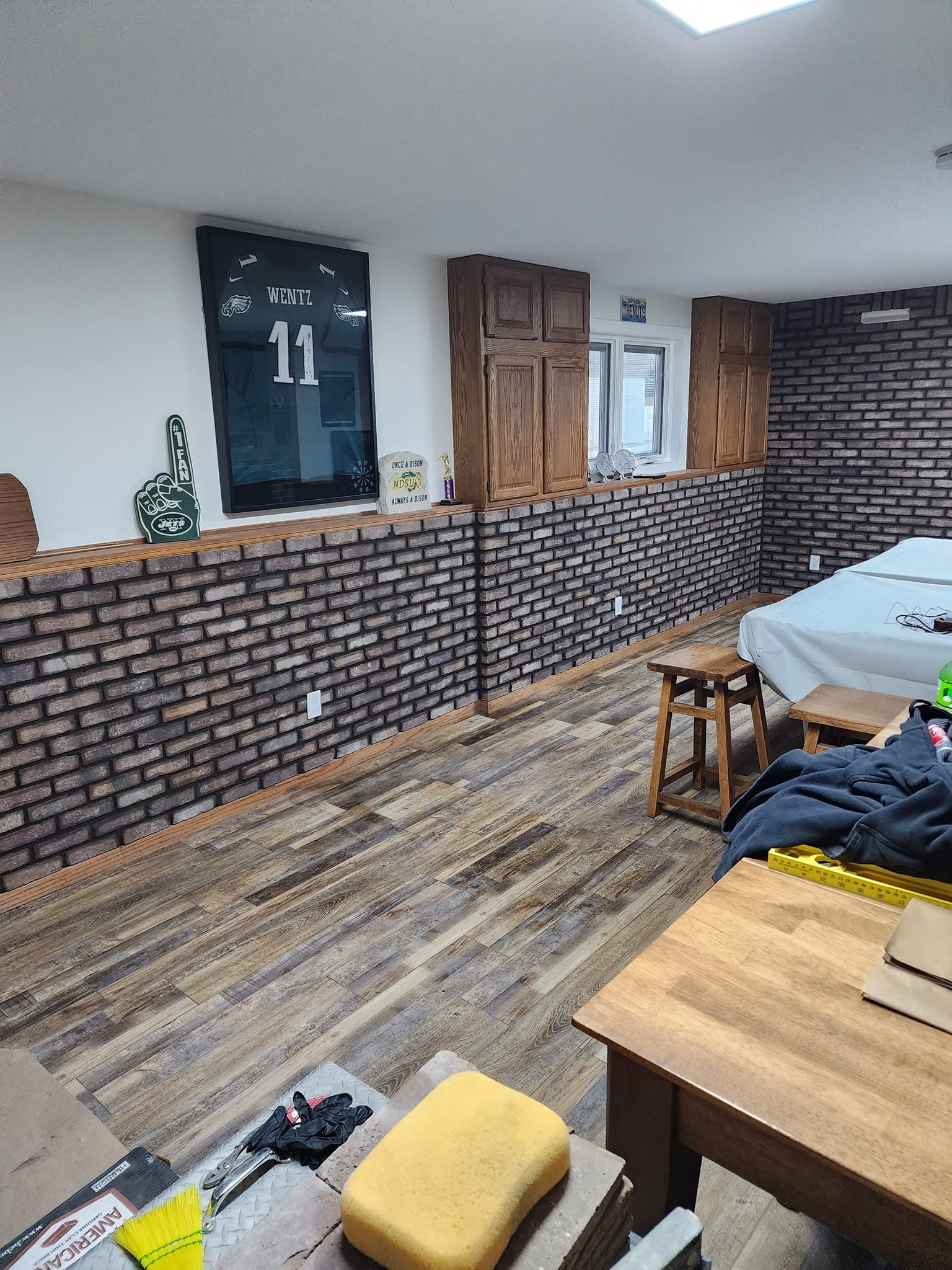 a living room with a bed, table, chairs, and a brick wall