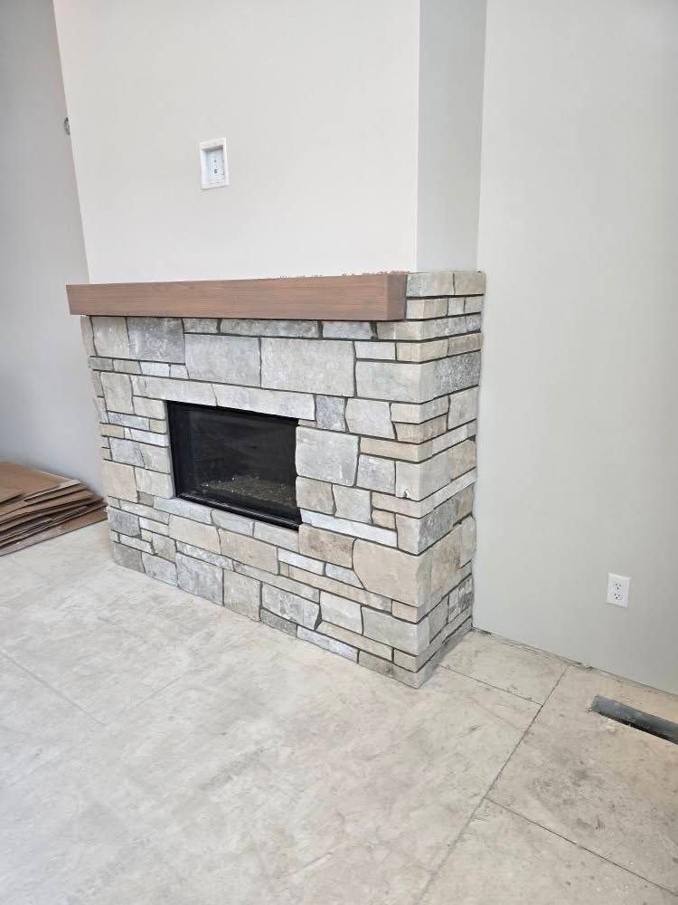 a stone fireplace with a wooden mantle in a living room