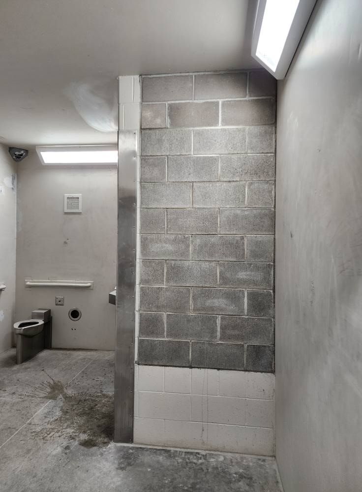 a bathroom with a brick wall and a toilet