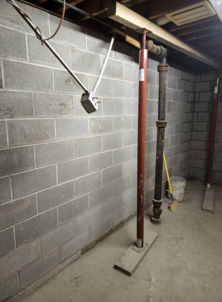 a basement with brick walls and pipes hanging from the ceiling