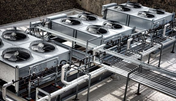 Industrial rooftop cooling units with large fans and connected metal ductwork