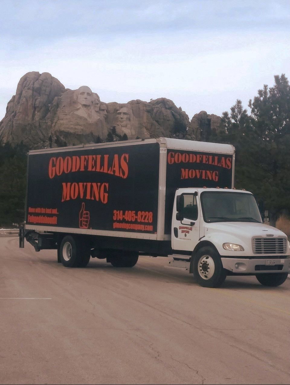 A Goodfellas moving truck driving in front of Mt Rushmore