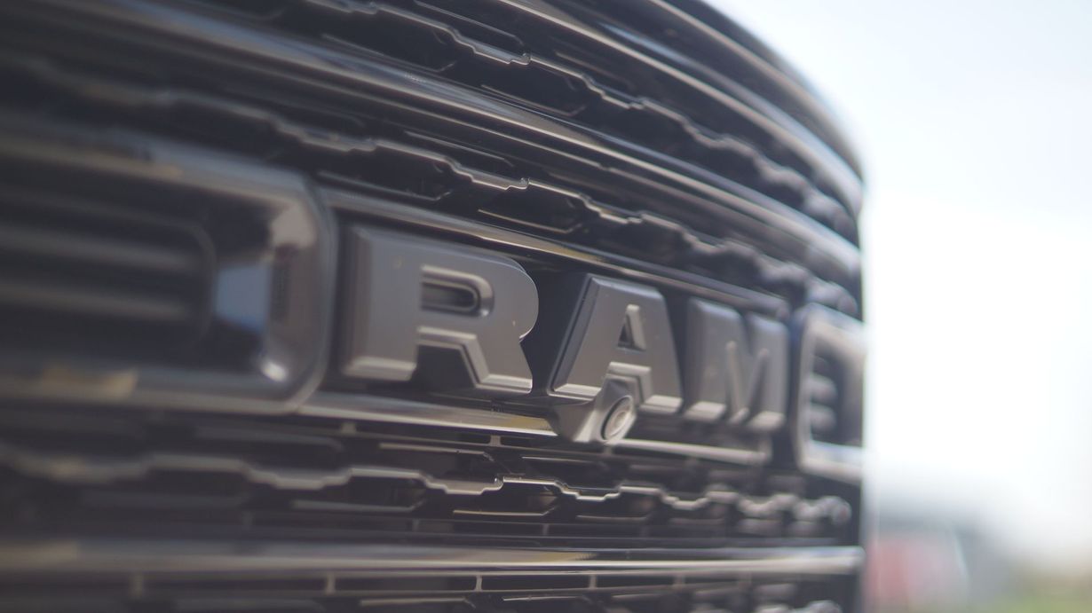 Close-up of a black RAM truck grill, the silver 