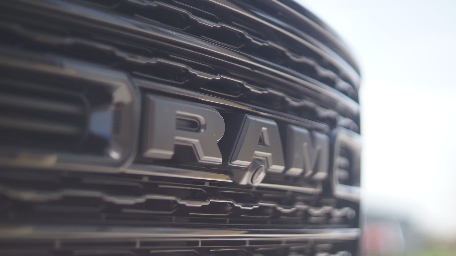 Close-up of a black RAM truck grill, the silver 