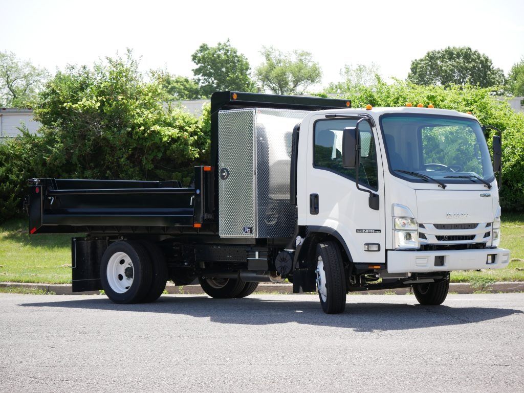 White Isuzu dump truck parked on a paved surface, with a black bed.