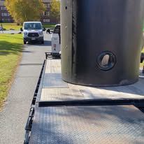A large black tank is sitting on top of a trailer.