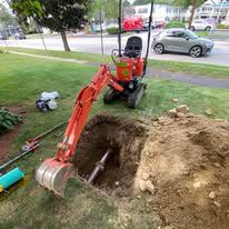 A small excavator is digging a hole in the ground.