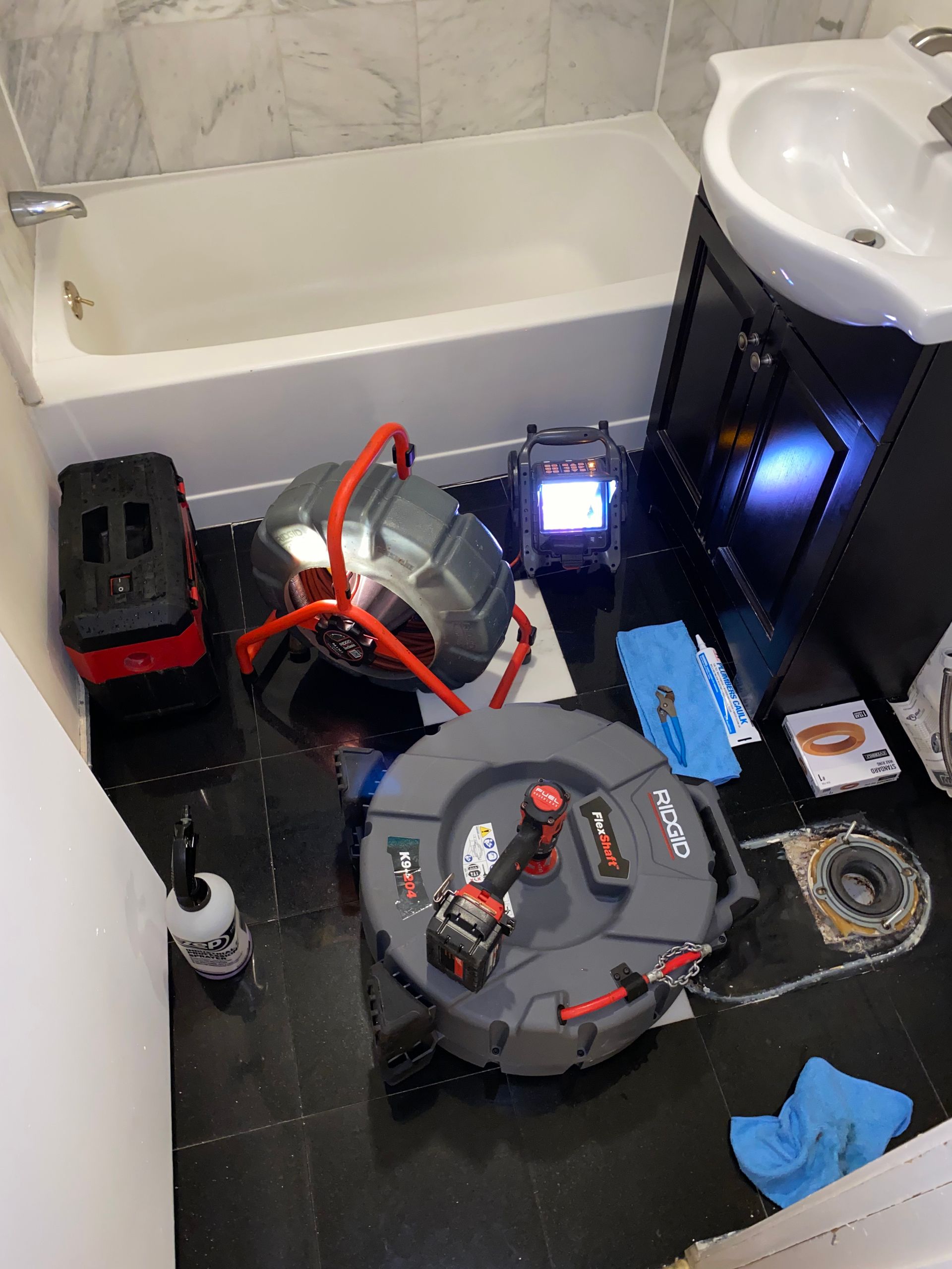 A bathroom with a sink and a drain snake