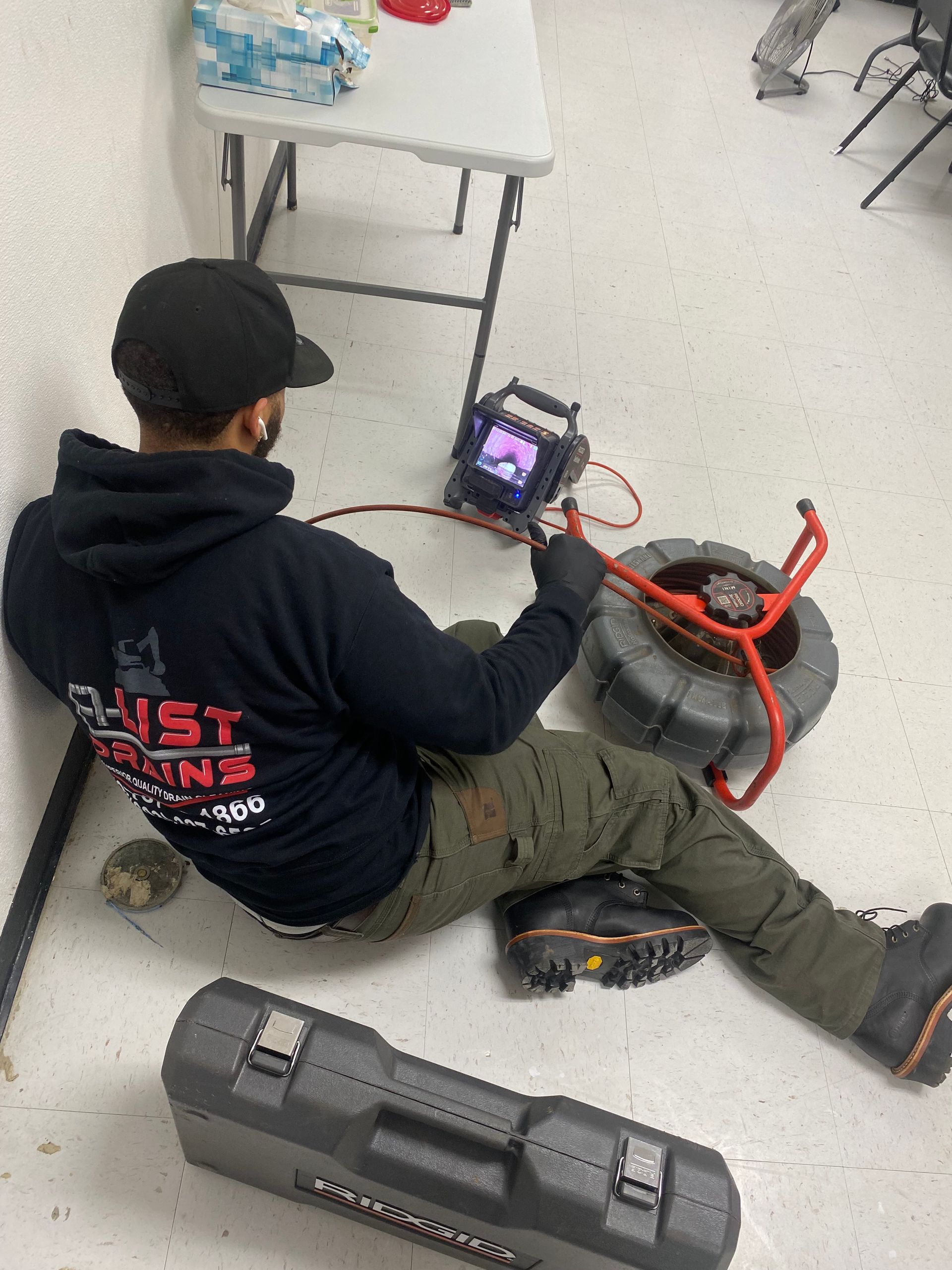 A man is laying on the floor looking at a camera.