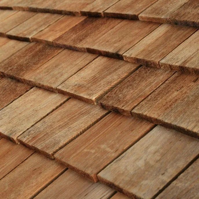 Close-up of overlapping wooden roof shingles in warm brown tones
