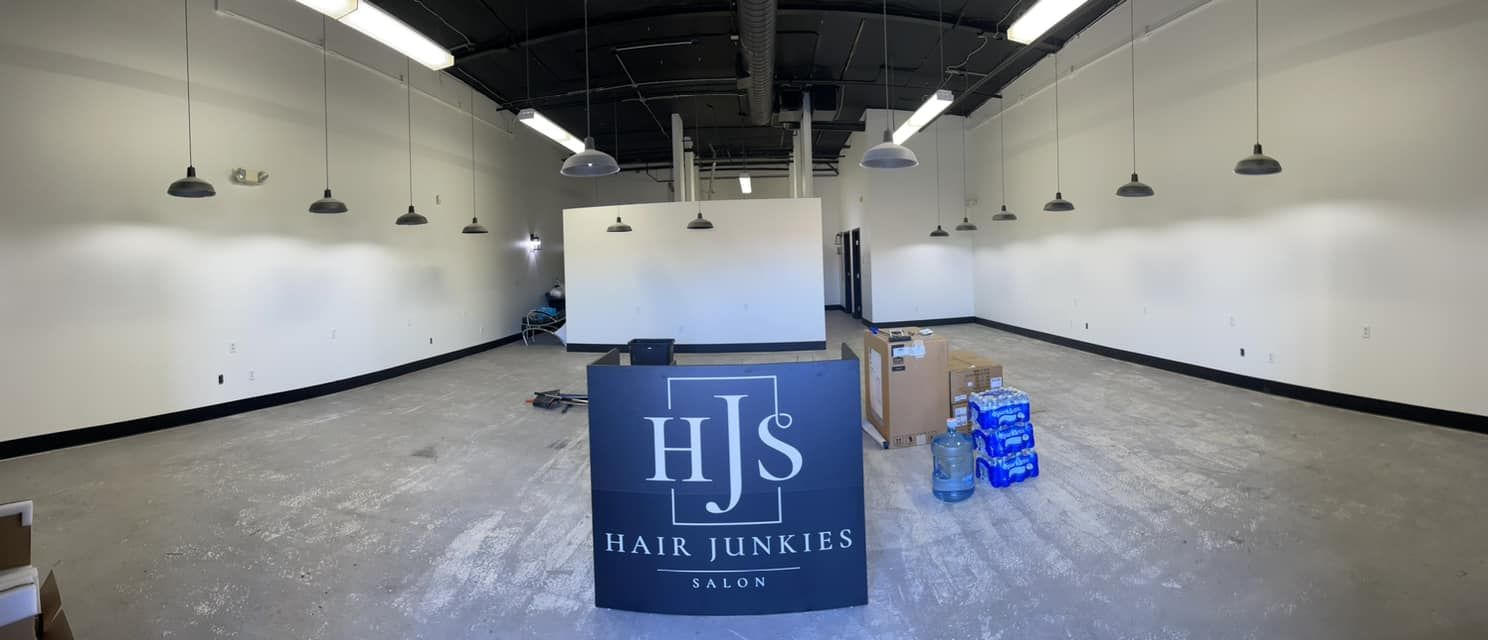 An empty salon space with a reception desk that says 