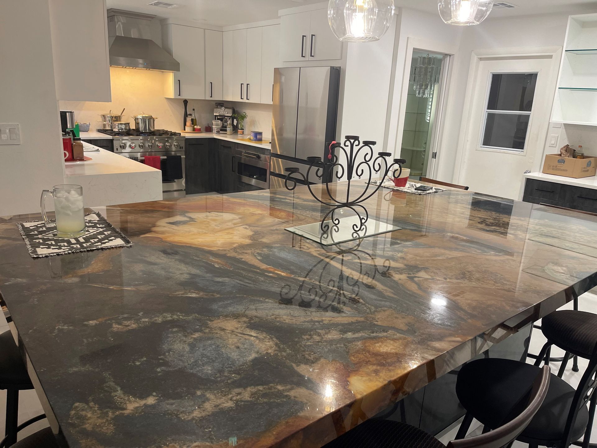 A kitchen with a large granite table and chairs.