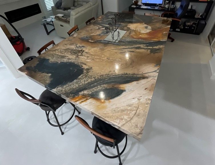 A large marble table with four chairs in a room.