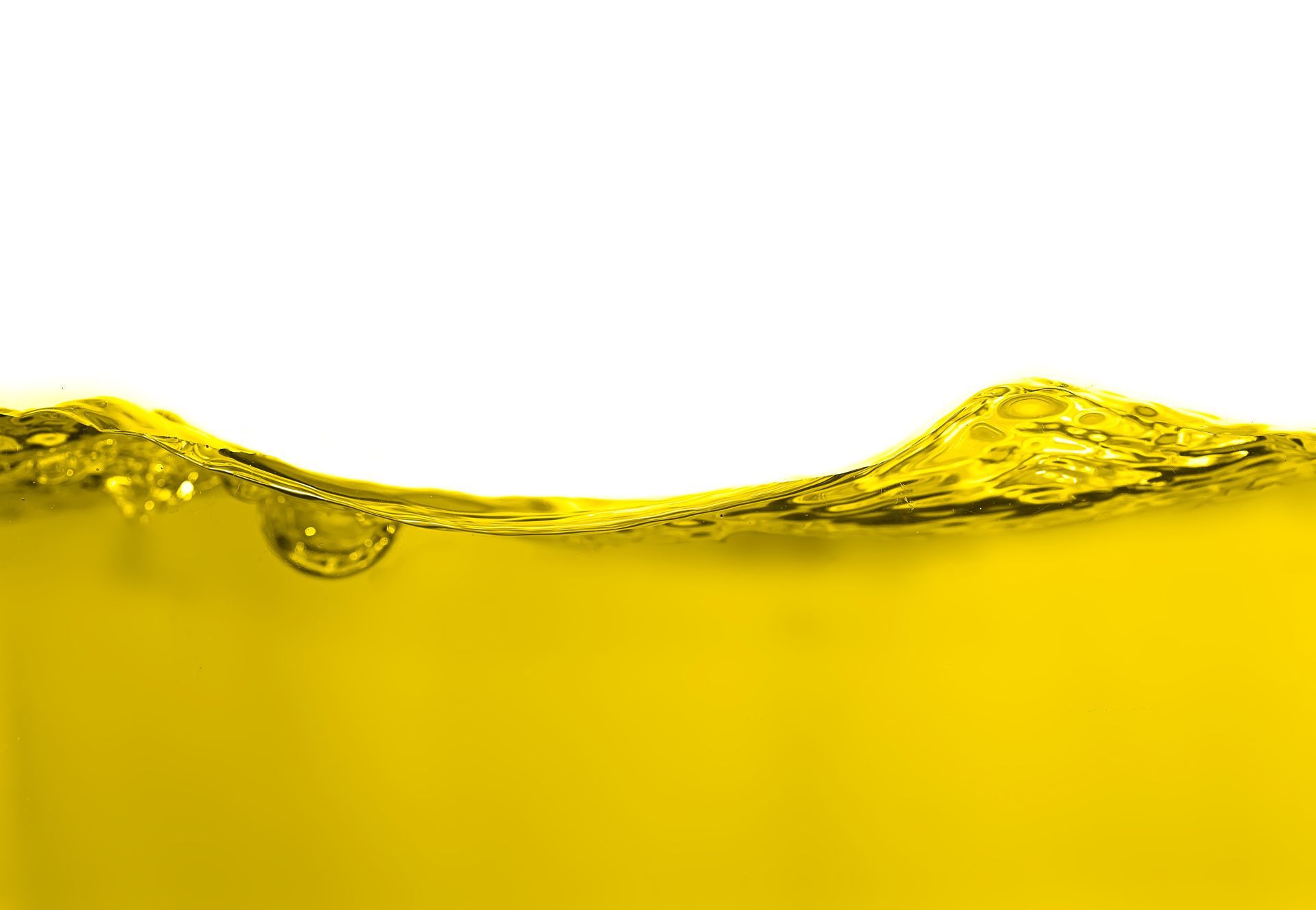Yellow liquid with rippling surface and bubbles against a white background
