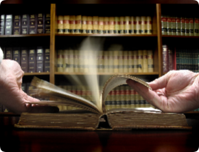 Hands turning pages in old law book with library in background