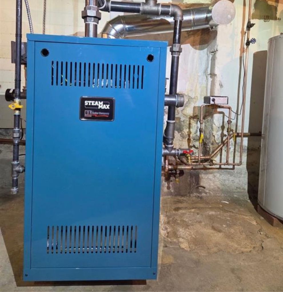 Blue STEAMAX boiler in a mechanical room with exposed pipes and valves