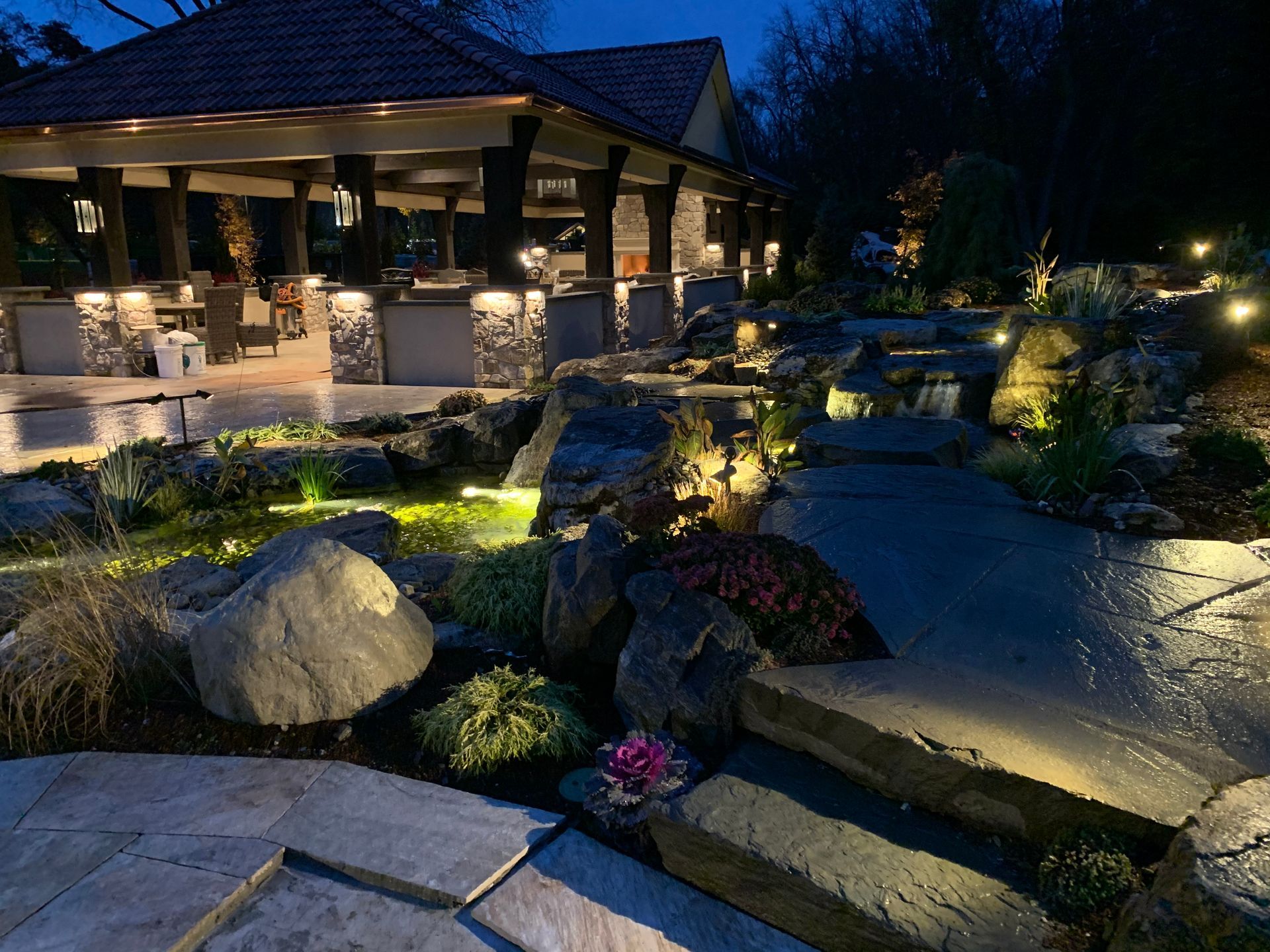 A house with a gazebo in the background is lit up at night.
