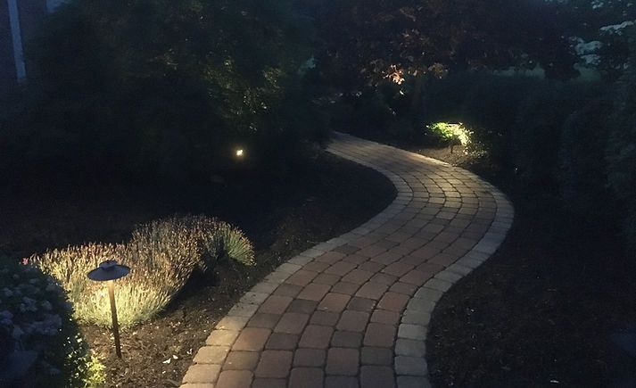 a brick walkway is lit up at night