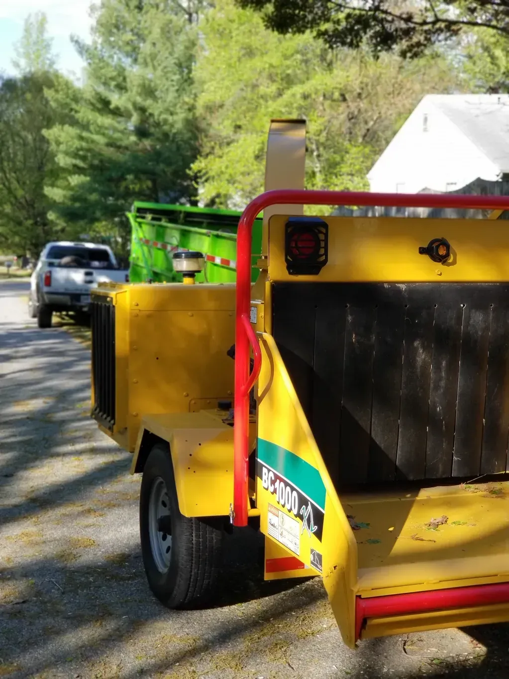 A yellow trailer with a green crane attached to it