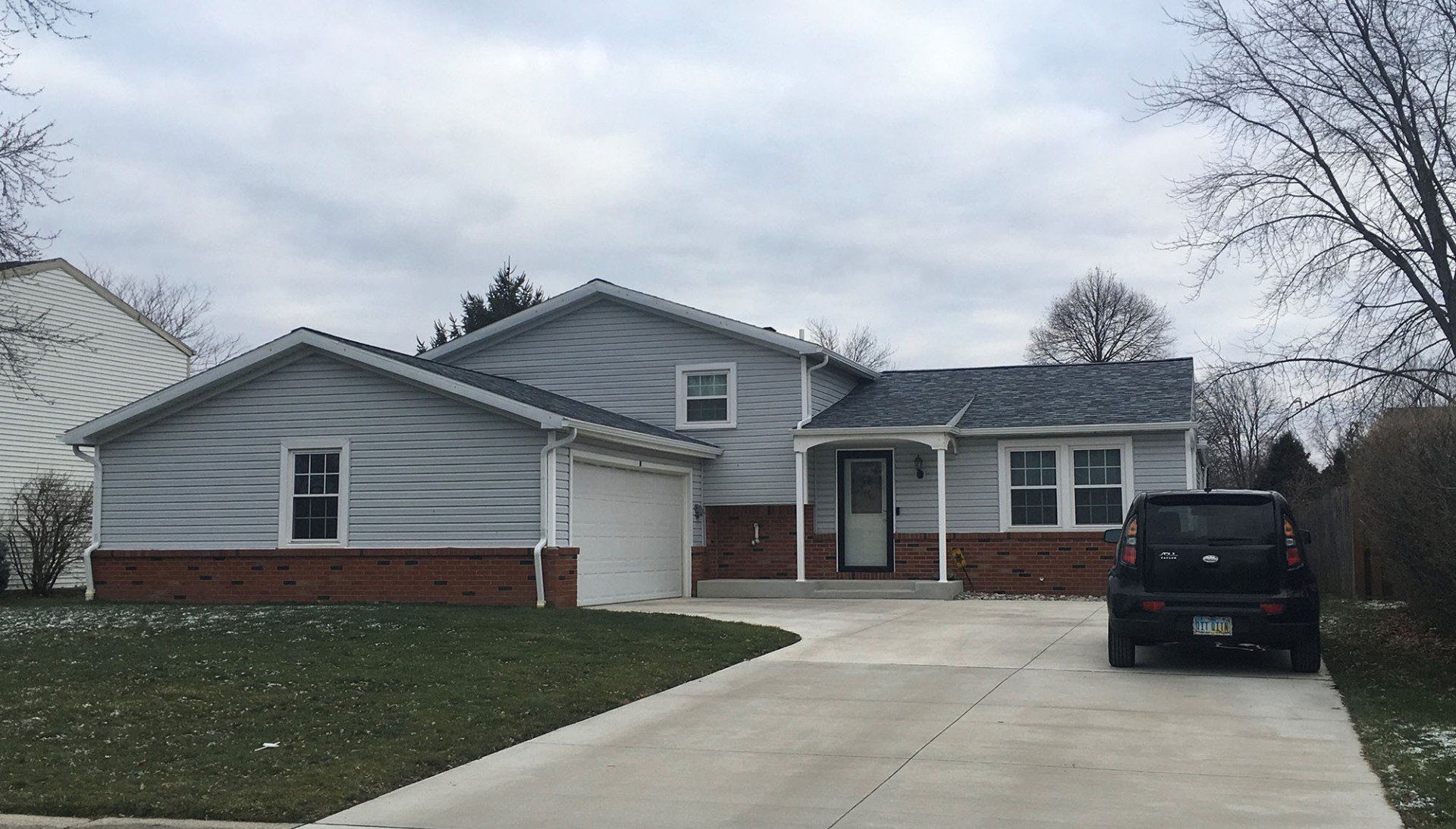 A light gray house with a driveway