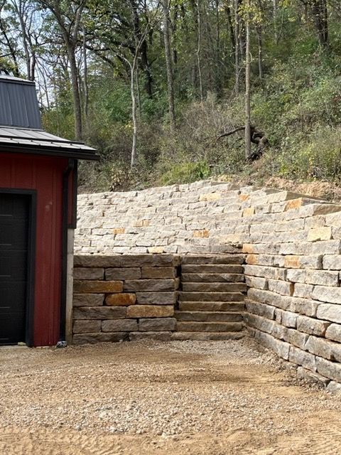 Blue house with gray roof, patio, and pergola on a sunny day.