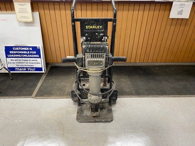 Stanley plate compactor on a floor, ready for use.