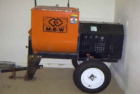 Orange and black M-B-W cement mixer on wheels, parked indoors.