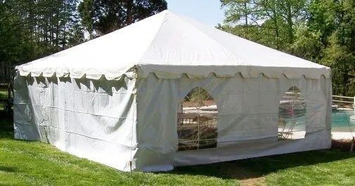 White party tent on green grass, outdoors.