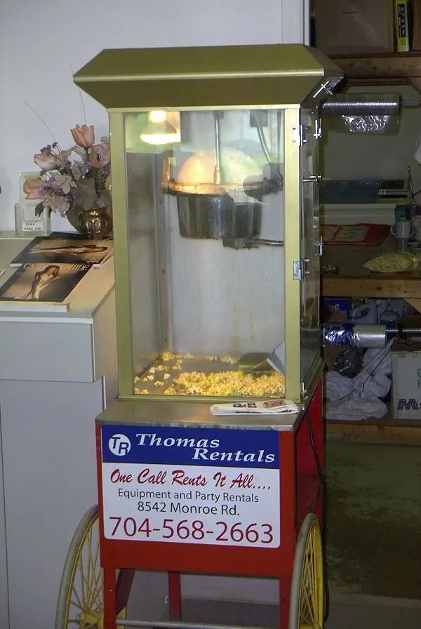 Popcorn machine for rental, gold and red, filled with popcorn, 