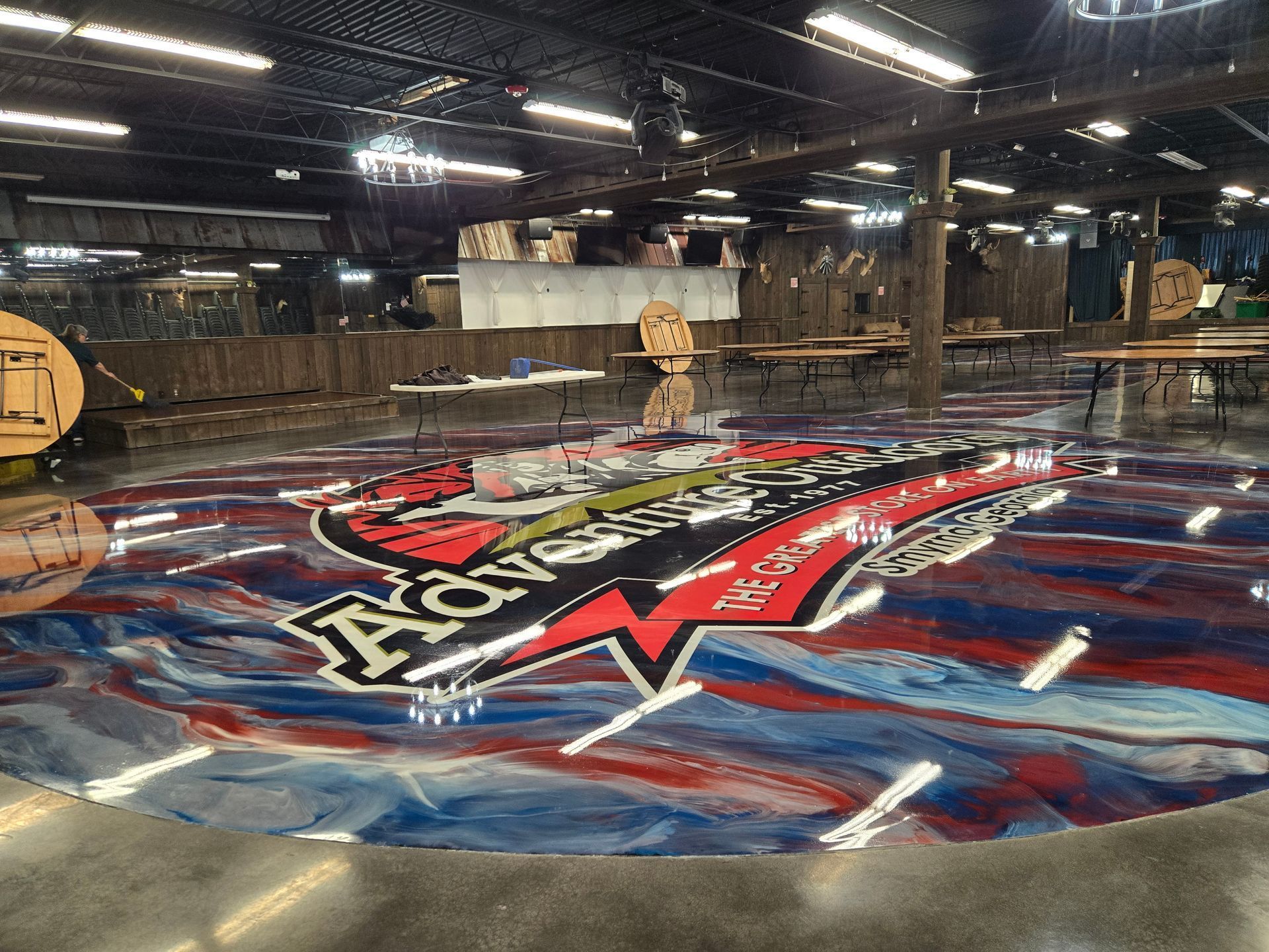 Large epoxy floor logo in an event space, red, white, blue with 