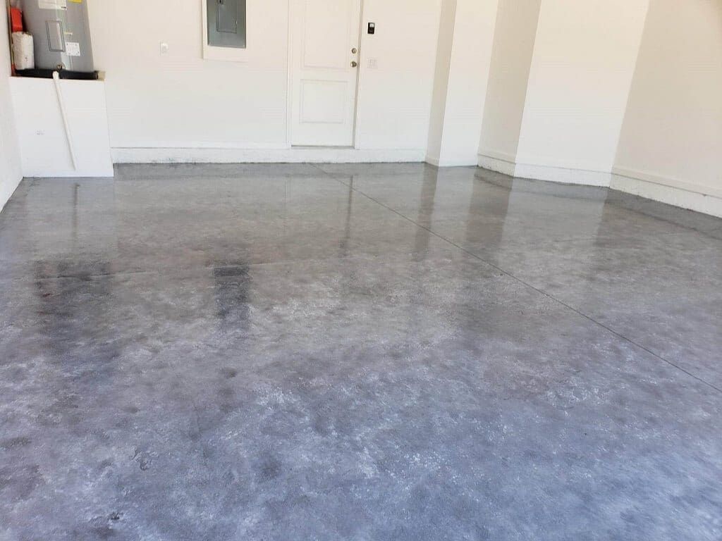 Glossy gray concrete floor in a bright, empty garage.