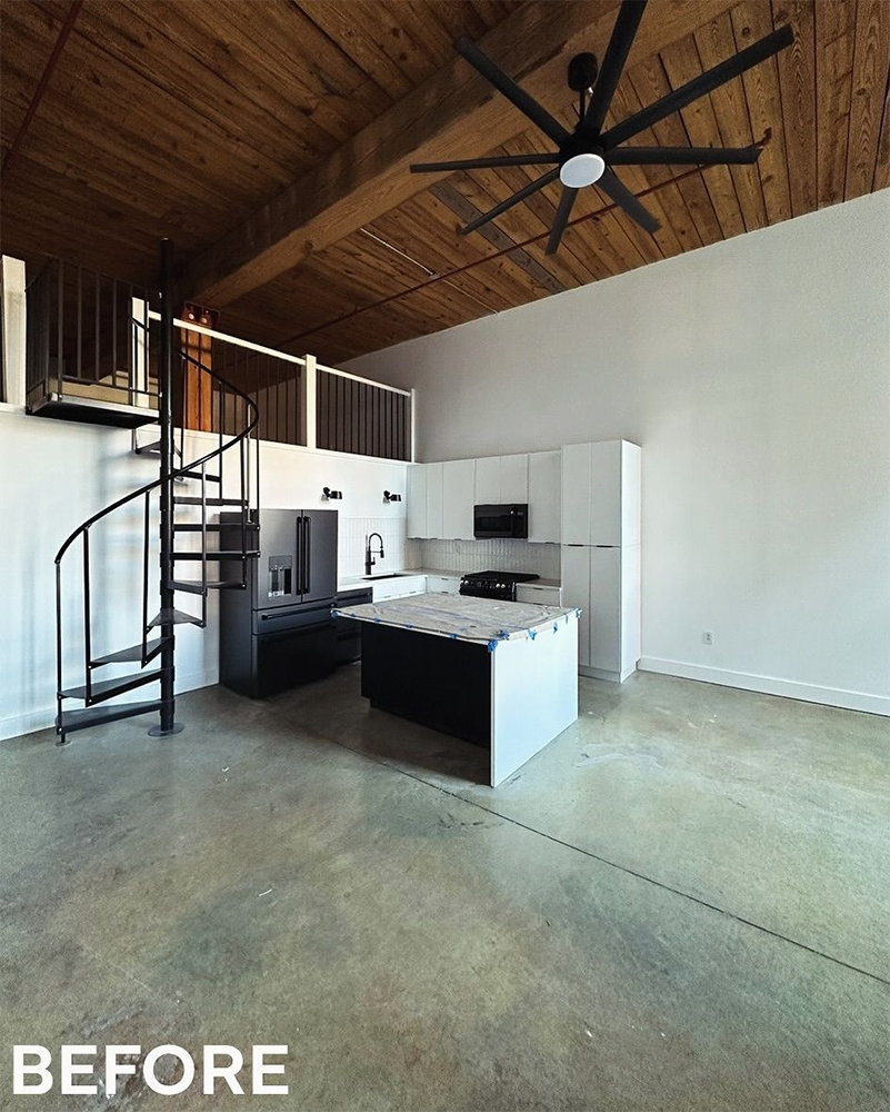 Loft kitchen with spiral staircase, high ceilings, exposed beams, and a large ceiling fan.