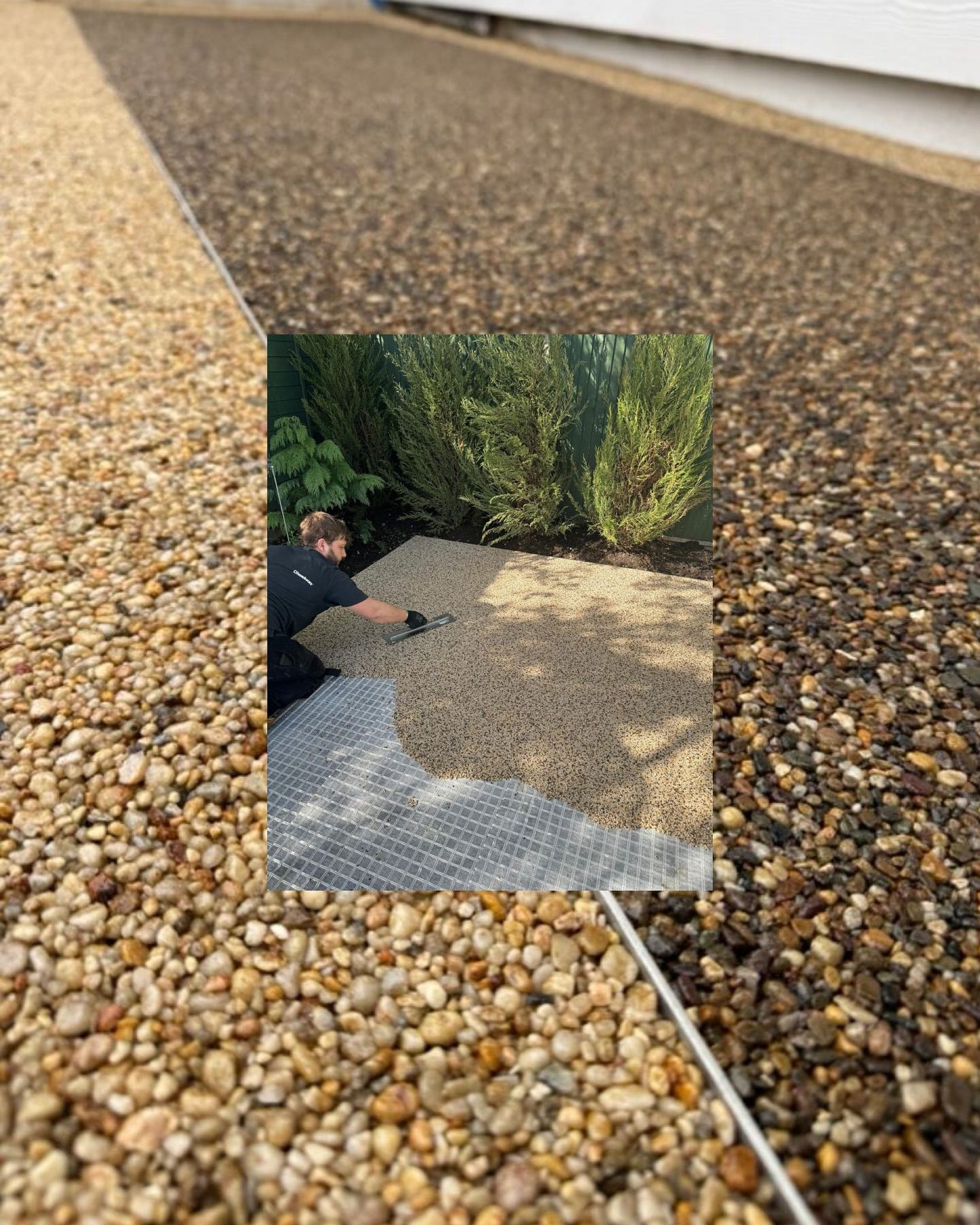 Person installing pebble paving on a driveway; two-tone brown and tan pebbles; green shrubs in the background.