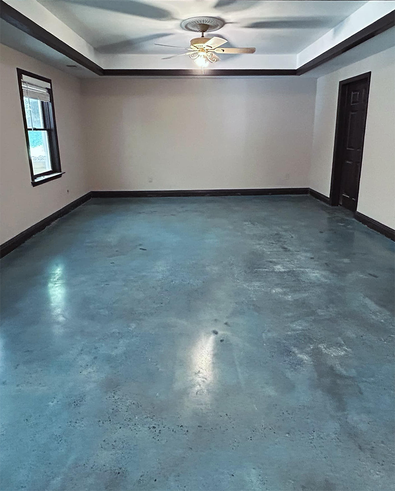 Empty room with grey concrete floor, beige walls, dark trim, and a ceiling fan.