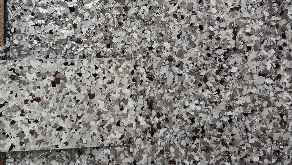 Close-up of a floor with gray, white, and dark brown flecks.