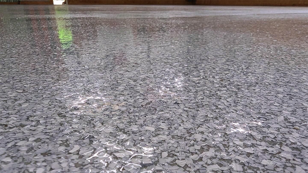Epoxy floor speckled with gray and white flakes, reflecting light.