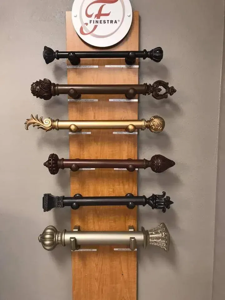 Six decorative metal door handles mounted vertically on a wooden display board.