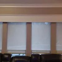 Window blinds above a leather couch in a living room