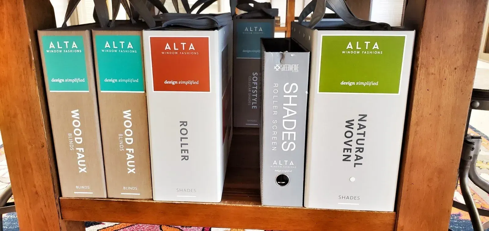 Colorful binders and books on a shelf, including white, orange, gray, and green spines with “A-ZA” labels.