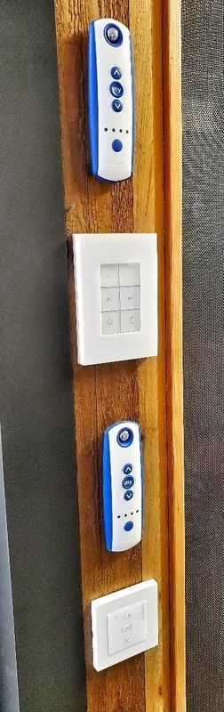 Close-up of four white wall-mounted control panels on a wooden surface.
