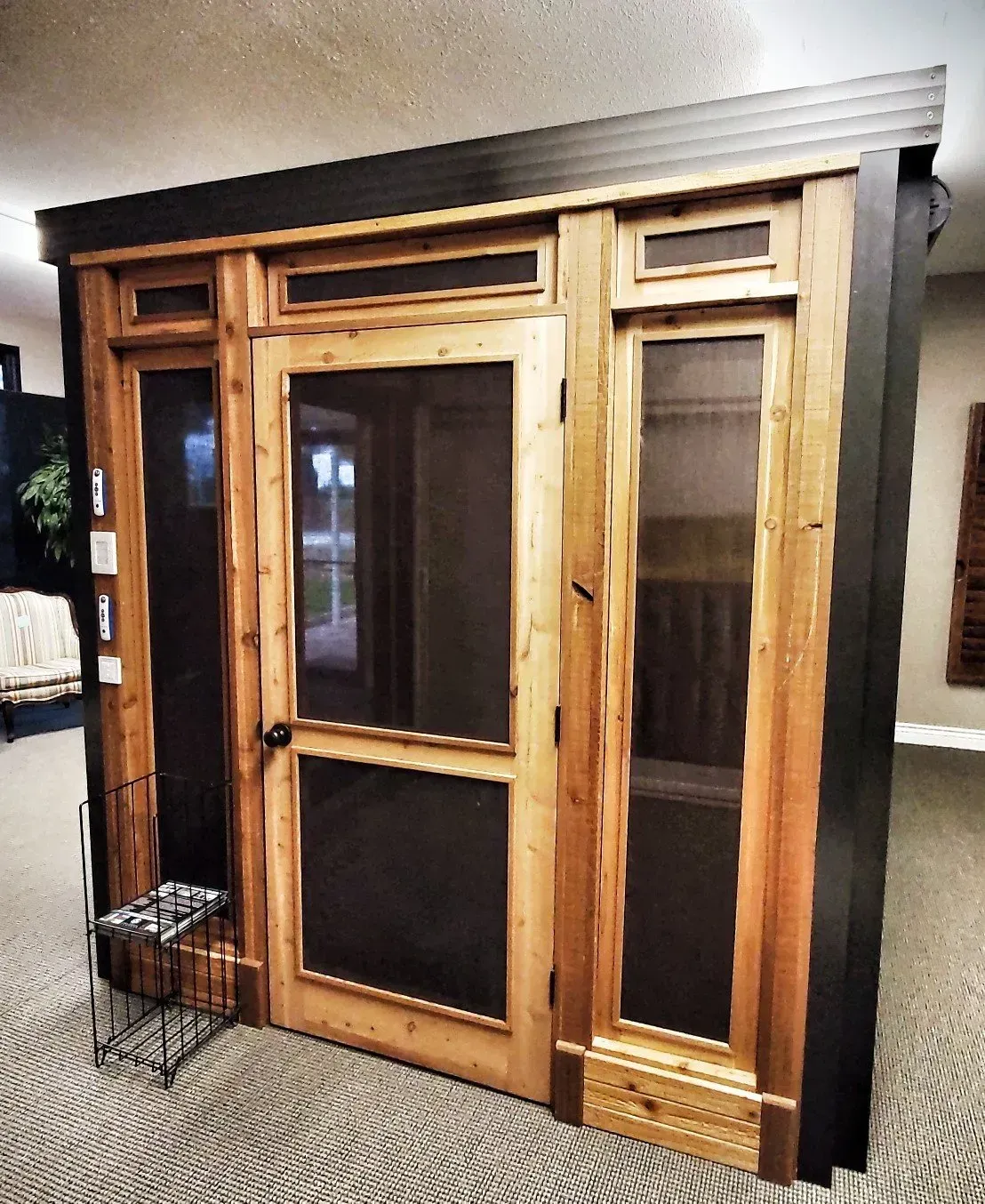 Wooden-framed glass door display cabinet with dark side panels in a showroom.