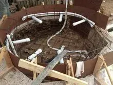 A hot tub is being built in a hole in the ground.