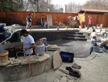 A group of people are working on a swimming pool.