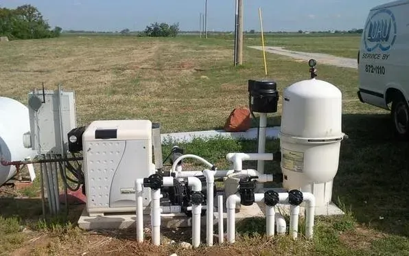 A white van with the word aqua on the side is parked in a grassy field.