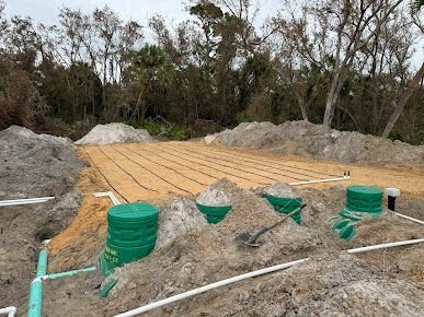 Septic system installation in sandy soil, featuring tanks, pipes, and leach field preparation.