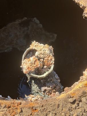 Corroded metal pipe in a dark, rusty environment.
