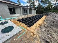 Septic system installation near a house. Black corrugated pipes in a trench.