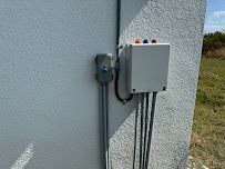 Electrical junction boxes and conduit on a stucco wall.