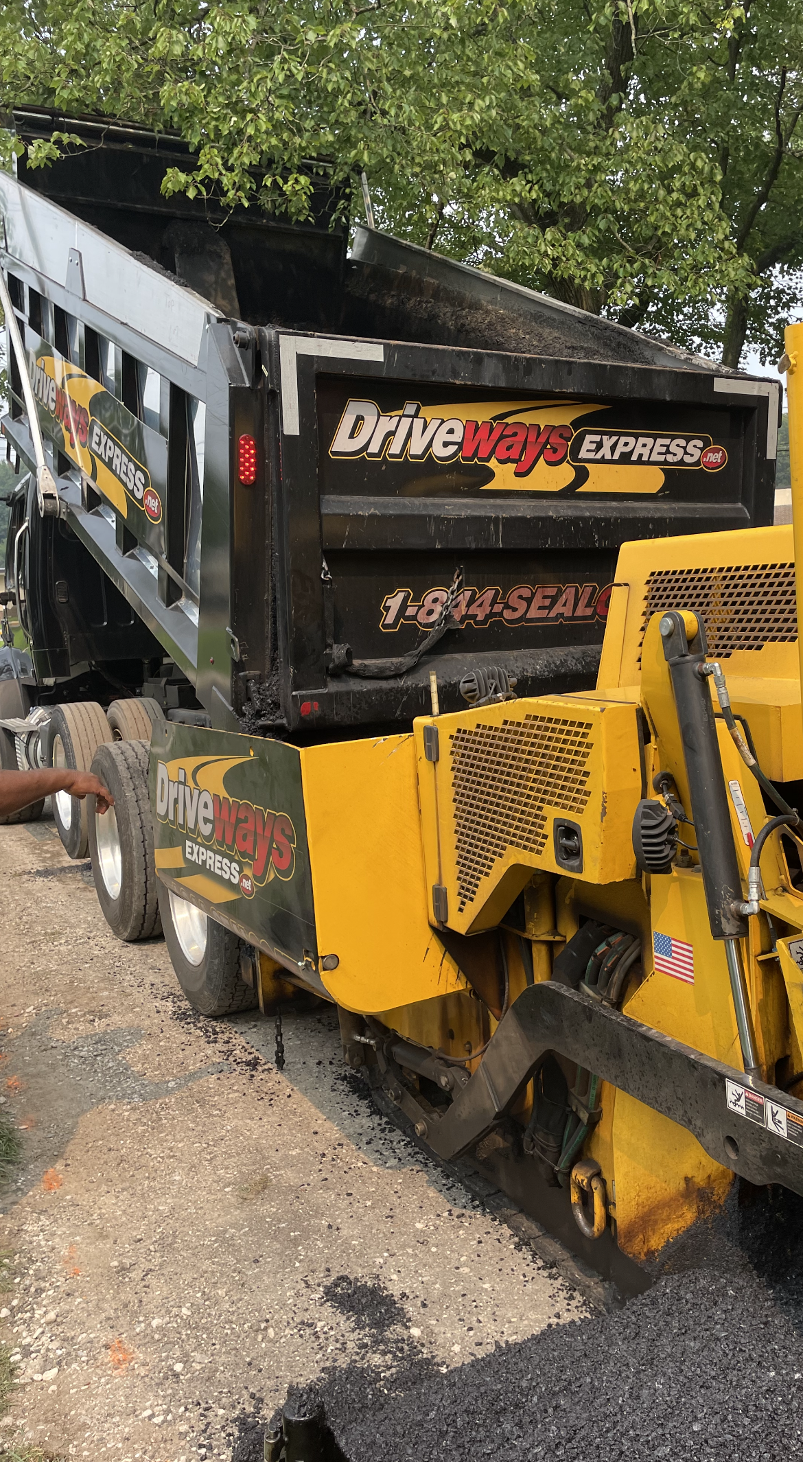 A dump truck is being loaded with asphalt